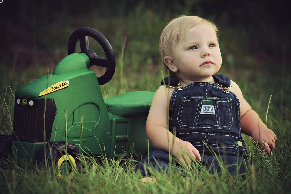 Baby mit Spielzeugtraktor
