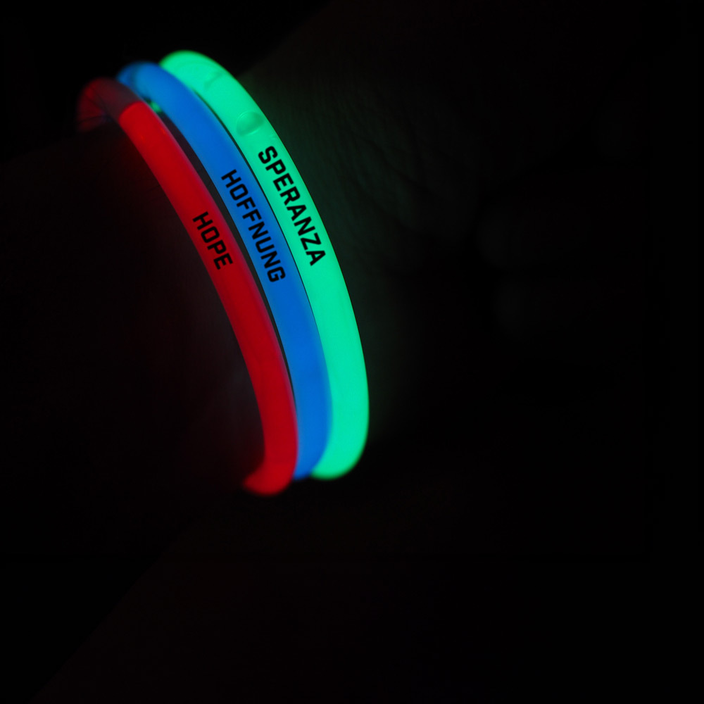 Leuchtende Silikonarmbänder mit den Worten Hoffnung, Hope und Speranza